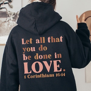 May include: Black hooded sweatshirt with the text "Let all that you do be done in LOVE. 1 Corinthians 16:14" printed on the back in pink and brown.