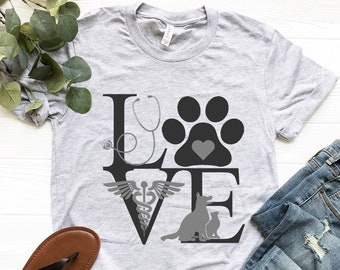 May include: A gray t-shirt with a graphic design of the word "LOVE" with a stethoscope, paw print, caduceus, and dog and cat silhouettes.