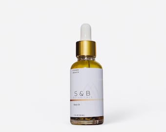 May include: A glass bottle with a gold cap and label. The label says "S&B Botanicals" and "Body Oil". The bottle contains a yellow liquid and is 1 fl oz (30 ml).