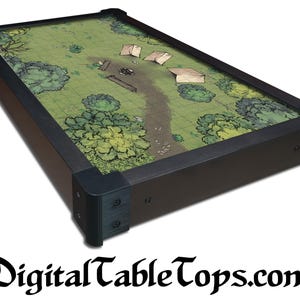 May include: A rectangular gaming table with a detailed map design. The table has a dark brown frame with black corner accents. The map features a green landscape with trees, a path, and tents. The website DigitalTableTops.com is displayed at the bottom.