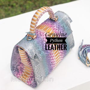 May include: A multi-coloured python leather handbag with a top handle and a detachable shoulder strap. The bag features a mix of silver, blue, purple, and gold tones. The text "Genuine Python Leather" is displayed on the front.