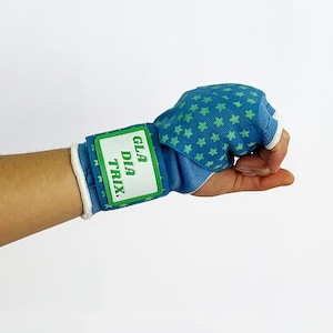 May include: Blue wrist wrap with green stars and a white label that says "GLADIA TRIX."