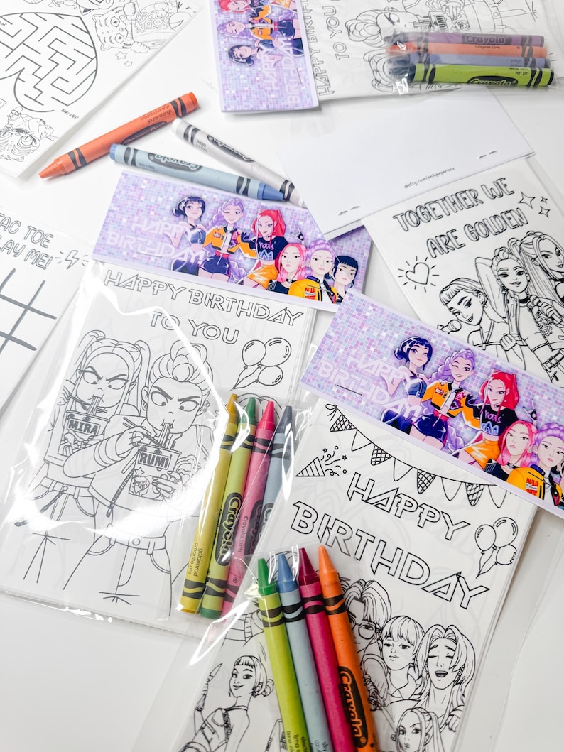 May include: A collection of coloring pages and crayons. The coloring pages feature line art illustrations with the text "HAPPY BIRTHDAY TO YOU" and "TOGETHER WE ARE GOLDEN". Several packs of Crayola crayons in various colors are also visible.