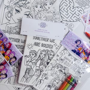 May include: A selection of colouring pages with line art illustrations of cartoon characters, including the text "OMG!", "Together We Are Golden", and "Happy Birthday Sophie". Includes a pack of crayons.