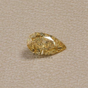 May include: A pear-shaped, lab-grown diamond with a vibrant yellow hue. The gemstone is faceted, reflecting light, and is set against a neutral background. The text "AKSHAR LAB GROWN" is visible.