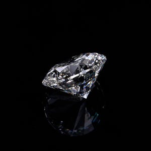 May include: A large, clear diamond with many facets, reflecting light. The diamond is set against a black background, creating a high-contrast image. The cut of the diamond is visible, showcasing its brilliance and clarity. The image highlights the gemstone's sparkle.