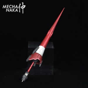 May include: A red and white plastic model kit of a spear weapon. The spear is pointed at the top and has a black handle.