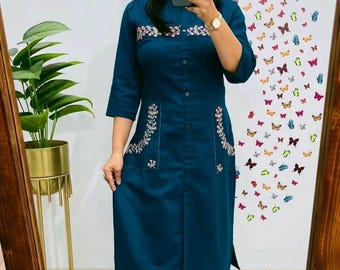 May include: A teal blue kurta with embroidered floral details and a matching pair of pants. The kurta has a button-up front and a long, flowing silhouette.