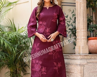 May include: A maroon cotton kurta with pink floral embroidery. The kurta has a V-neckline and 3/4 sleeves with scalloped edges. The pants are also maroon and have a straight leg.
