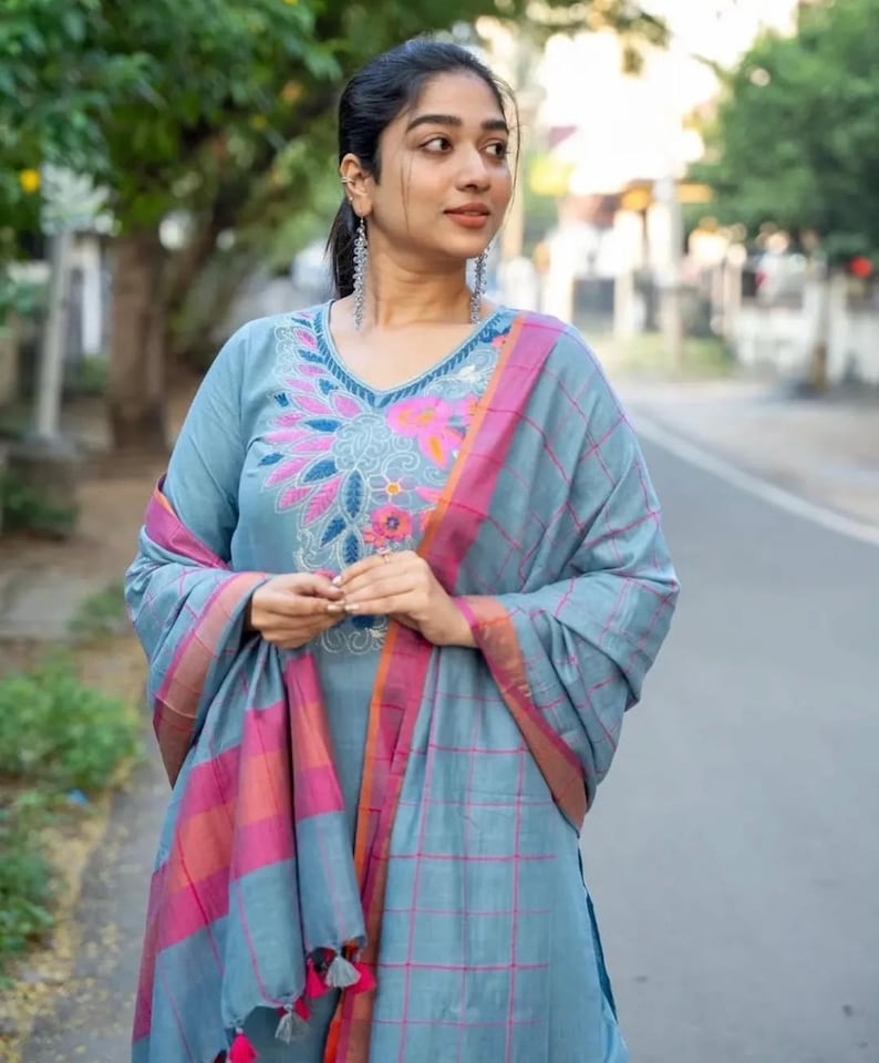 Peut inclure: Une femme portant une kurta bleu clair avec des broderies roses et orange et un dupatta bleu clair assorti avec des carreaux roses et orange.
