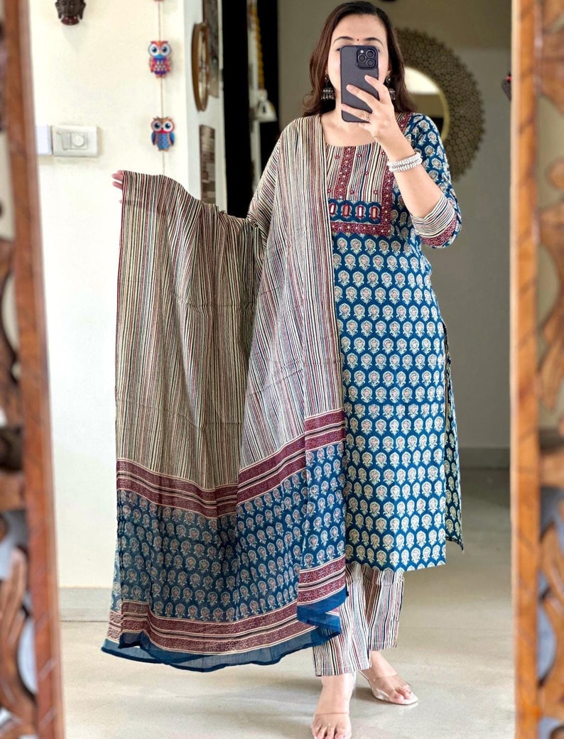 May include: A blue and white printed cotton kurta with a matching palazzo pant and a striped dupatta. The kurta has a maroon embroidered neckline and the dupatta has maroon stripes.