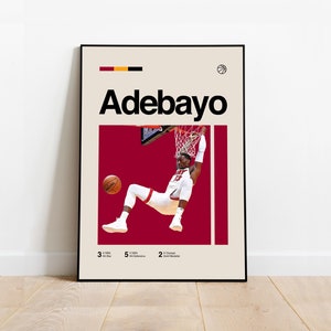 Peut inclure: Une affiche de basket-ball représentant un joueur en plein dunk. L'affiche a un fond rouge avec le nom du joueur, "Adebayo", en texte noir en haut. L'affiche comprend également les statistiques du joueur : 3x NBA All-Star, 5x NBA All-Defensive et 2x médaillé d'or olympique.