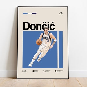 May include: A poster featuring a basketball player in a blue jersey with the word "DALLAS" and the number "77" on it. The player is dribbling a basketball and is in mid-air. The poster also includes the player's name "Dončić" in large, bold letters. The poster has a blue background and a beige border.