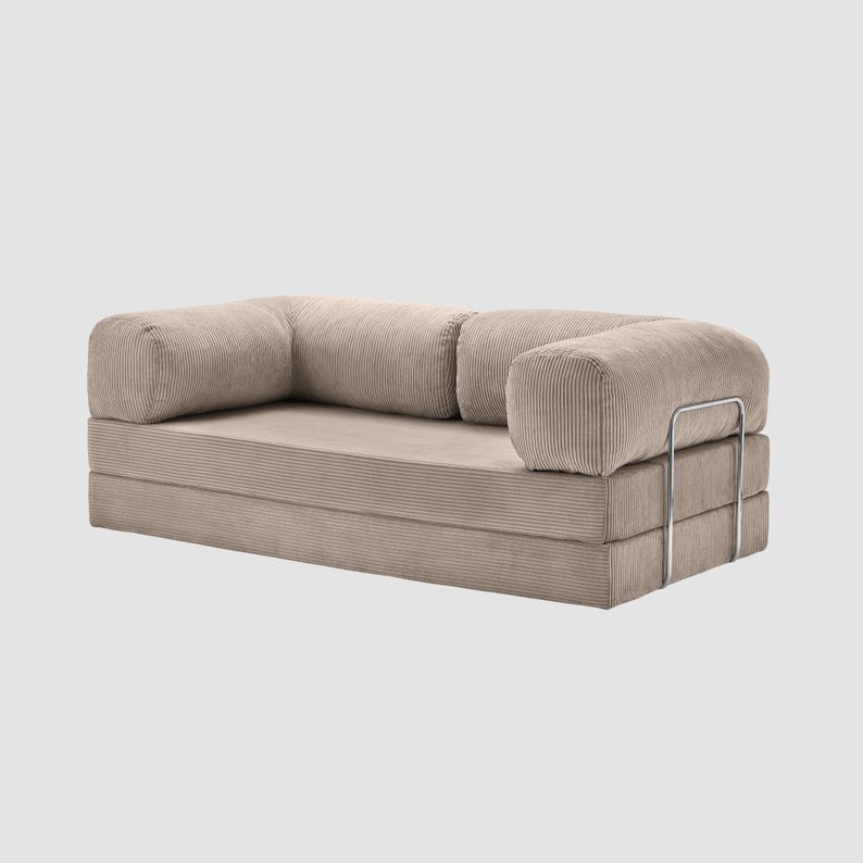 May include: A beige corduroy sofa with rounded armrests and a low profile. The sofa has a modular design with a metal support frame. The fabric has a ribbed texture, and the overall aesthetic is modern and minimalist.