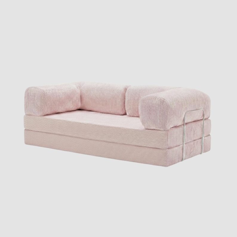 Puede incluir: Un sof&aacute; rosa claro de estilo moderno con textura de pana. El sof&aacute; tiene una base rectangular y reposabrazos redondeados. Un marco de metal plateado es visible en el lateral. El sof&aacute; est&aacute; dise&ntilde;ado para la comodidad y el estilo.