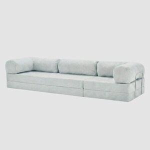 May include: A light blue modular sofa with a corduroy texture. The sofa has a low profile with a rectangular shape and rounded armrests. A silver metal frame supports the armrest. The sofa is designed for comfort and modern living.