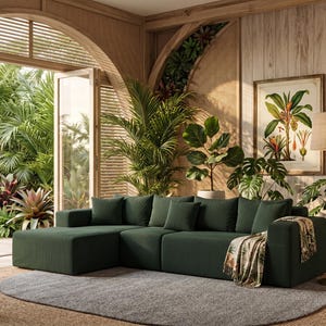 May include: A dark green sectional sofa with several matching throw pillows. The sofa is in a room with a large window overlooking a lush garden. A botanical print and a floor lamp are also visible.