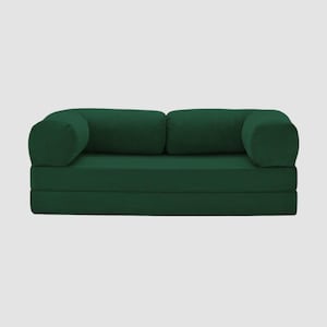 Puede incluir: Un sof&aacute; verde oscuro con textura de pana y reposabrazos y cojines traseros redondeados. El sof&aacute; es de un color verde bosque intenso y parece modular, con un dise&ntilde;o plegable. La est&eacute;tica general es moderna y minimalista.