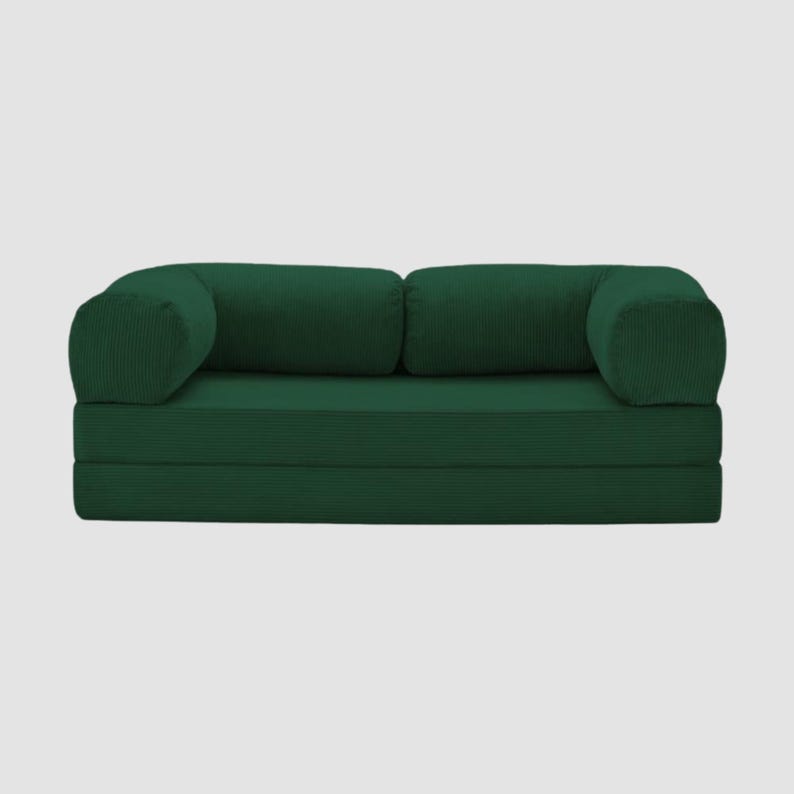 Puede incluir: Un sof&aacute; verde oscuro con textura de pana y reposabrazos y cojines traseros redondeados. El sof&aacute; es de un color verde bosque intenso y parece modular, con un dise&ntilde;o plegable. La est&eacute;tica general es moderna y minimalista.