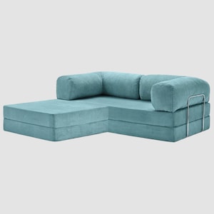 May include: A sectional sofa in a light teal corduroy fabric. The sofa has a chaise lounge on one side and a rounded armrest on the other. The back cushions are rectangular and the sofa has a metal frame.