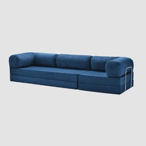 May include: A modular blue corduroy sofa with rounded armrests and backrests. The sofa has a low profile and a modern design, with a metal frame on the armrest. The sofa is made of a soft, textured fabric.