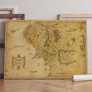 May include: A framed map of Middle Earth, with detailed geographical illustrations in brown and black. The map includes text such as "The Sundering Seas" and "Middle Earth". A compass rose is in the upper right corner.