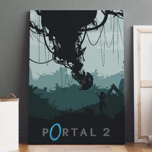May include: A rectangular wall art print featuring a silhouette of a large mechanical structure hanging above a landscape with debris. A small figure stands below holding a glowing blue object. The text PORTAL 2 is printed at the bottom in gray.