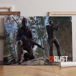 Pode incluir: Impressão em tela com duas figuras em equipamento tático, segurando rifles, em um cenário de floresta. A palavra "RUST" é exibida em um logotipo vermelho e branco. As figuras usam capacetes e roupas escuras.