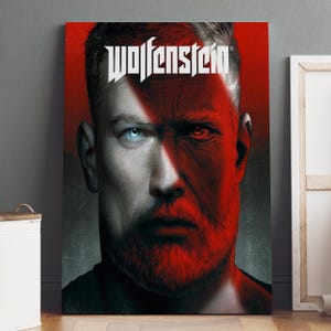 May include: A canvas print featuring a split-face portrait with the word "Wolfenstein" in white block letters. One side of the face is white with a blue eye, the other is red with a red eye. The subject has a red beard.