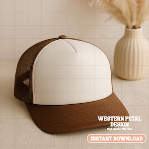 May include: A brown and white trucker hat with a curved peak. The hat has a brown mesh back, a white front panel, and a brown peak. The text "WESTERN PETAL DESIGN" and "INSTANT DOWNLOAD" are visible.