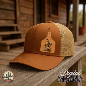 Pode incluir: Um chapéu de caminhoneiro marrom e bege com um remendo de couro que diz "Ride or Die" e apresenta a silhueta de um cowboy montando a cavalo.