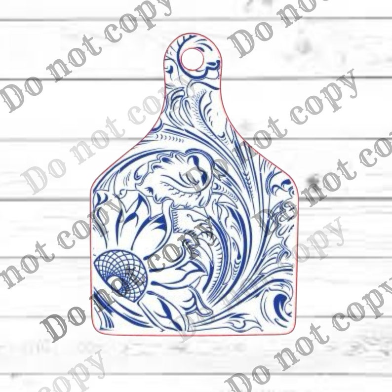 May include: A white and blue floral design on a cow tag. The design features a large sunflower with intricate swirls and flourishes.