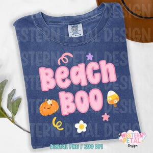 May include: A navy blue t-shirt with the words "Beach Boo" in pink bubble letters, along with a pumpkin, ice cream, and other graphics. The shirt is a Comfort Colors brand, size L-G.