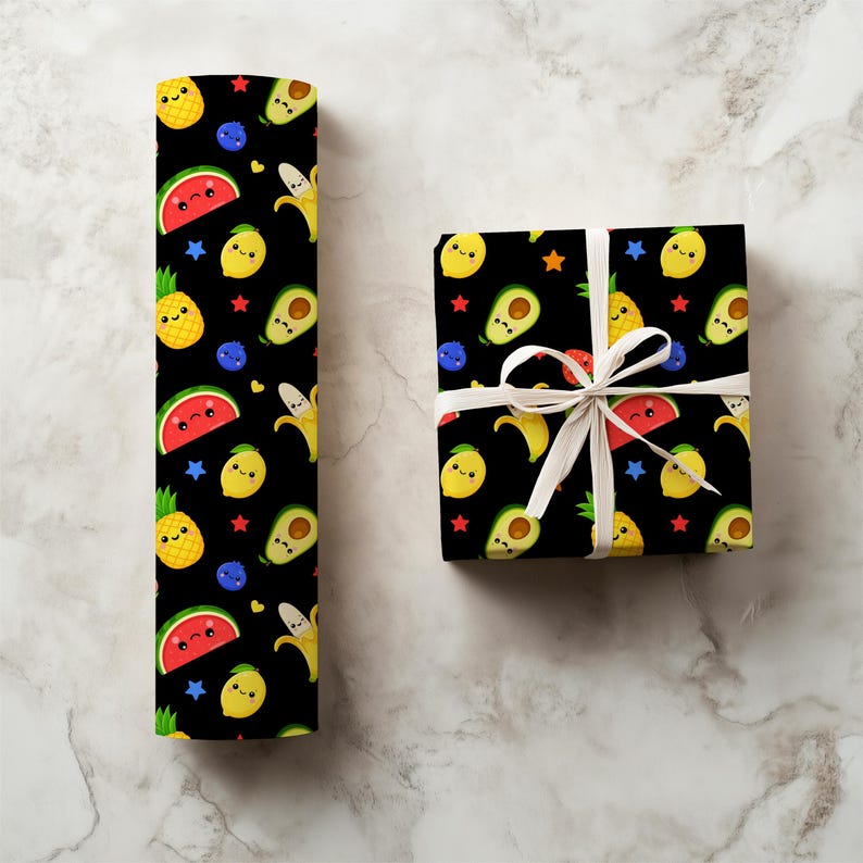 May include: Black wrapping paper and a wrapped gift box feature a repeating pattern of smiling fruit illustrations. The design includes watermelons, pineapples, lemons, avocados, bananas, blueberries, and stars. The gift box is tied with a white ribbon.