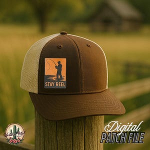 Pode incluir: Boné de caminhoneiro marrom e bege com um patch marrom que apresenta a silhueta de uma pessoa pescando e o texto "STAY REEL".