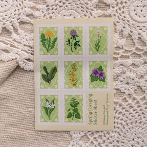 May include: A sheet of 6 spring foraging stickers. The stickers are stamp-shaped and feature illustrations of various plants and flowers, including a dandelion, clover, and a purple flower. The stickers are waterproof vinyl.