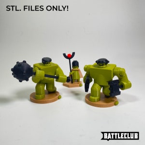 May include: Three 3D printed figurines, two green and one brown, with black accents. The green figurines are holding weapons, and the brown figurine is wearing a crown. The text "STL. FILES ONLY!" is visible in the background.