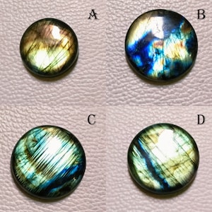 May include: Four round labradorite gemstones with iridescent blue, green, and gold colors. The gemstones are labeled A, B, C, and D.