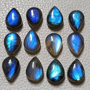 May include: Twelve teardrop-shaped labradorite gemstones with iridescent blue and green hues.