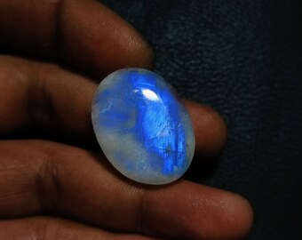 Può includere: Una pietra preziosa di cabochon ovale in pietra di luna blu e bianca con bagliori blu iridescenti.