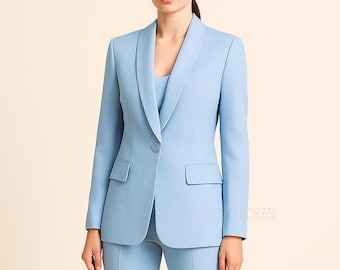 Puede incluir: Un blazer azul claro y pantalones a juego. El blazer tiene cuello chal, cierre de un solo botón y dos bolsillos delanteros. El conjunto es de color liso y parece estar hecho de una tela suave. El texto "COUTURE BESPOKEN" es visible en la parte inferior derecha.