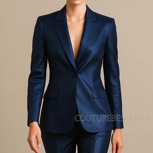 Könnte beinhalten: Ein marineblauer Anzug, bestehend aus Jacke und Hose. Die Jacke hat einen Ein-Knopf-Verschluss, ein fallendes Revers und zwei Vordertaschen. Der Anzug ist aus einem glänzenden Stoff gefertigt. Der Text "COUTUREBESPOKEN" ist unten rechts sichtbar.