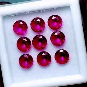 Peut inclure: Neuf pierres précieuses rondes et facettées de couleur rubis rouge dans un coffret de présentation carré blanc.