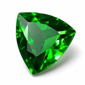 May include: A vibrant, deep green gemstone cut into a triangular shape with multiple facets. The stone exhibits high clarity and brilliance, reflecting light across its polished surfaces to create a sharp, geometric appearance against a white background.