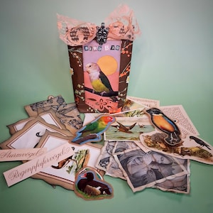 Könnte beinhalten: Ein Set aus drei Keramikbechern mit gesprenkelter, matter Oberfläche. Die Becher sind in Creme-, Hellgrau- und Dunkelgrautönen gehalten. Jeder Becher hat ein schlichtes, minimalistisches Design und einen abgerundeten Henkel.