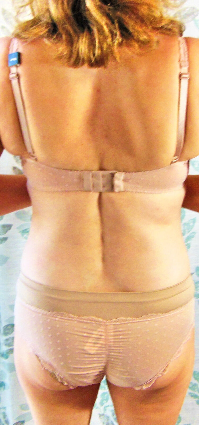 May include: A nude-colored bra and matching underwear with a polka dot pattern. The bra has adjustable straps and a hook and eye closure in the back. The underwear has a lace trim.