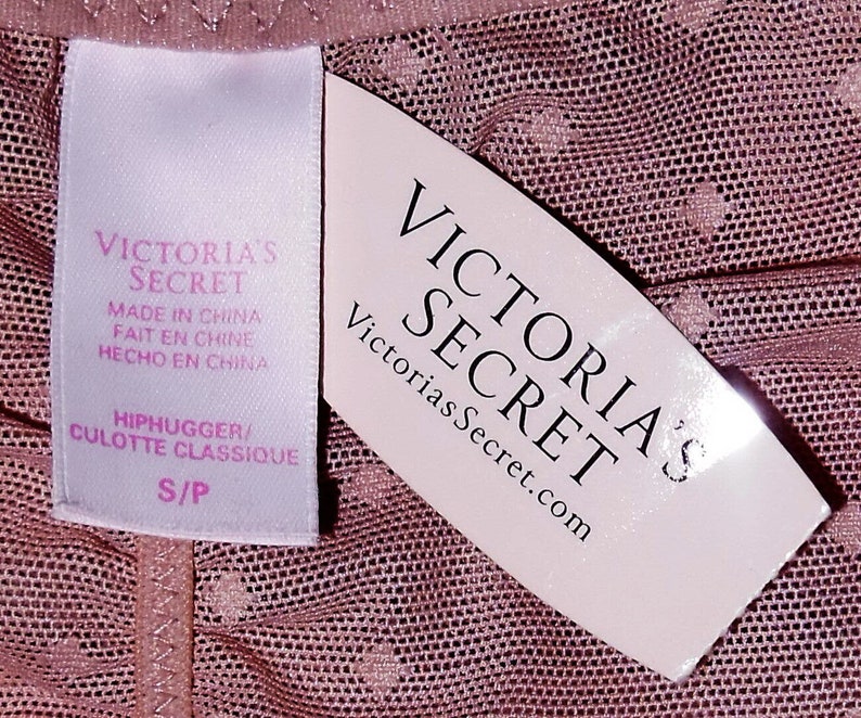 May include: A pink mesh fabric with a white tag that says "Victoria's Secret" and "Hiphugger/Culotte Classique S/P". The tag also says "Made in China, Fait en Chine, Hecho en China".