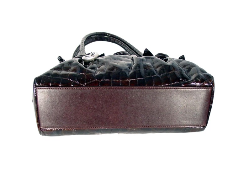 Pu&ograve; includere: Una borsa a mano in pelle marrone con stampa coccodrilo e chiusura argentata. La borsa &egrave; foderata in pelle marrone.