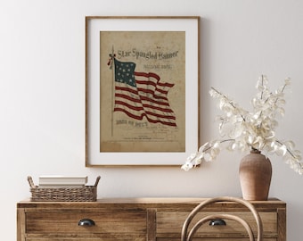 May include: Vintage print of the "Star Spangled Banner" national song with a depiction of an American flag waving in the wind. The print is framed in a light wood frame.