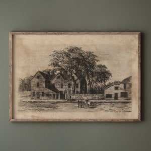May include: A black and white print of a historical building with a large tree in front. The building has multiple windows and a wooden door. The print is framed in a brown wooden frame.